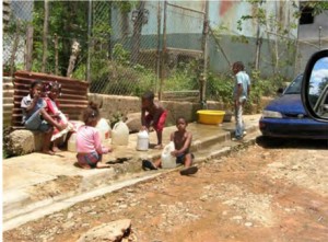 Children of Miramar collecting water from a leaking Municipal tank